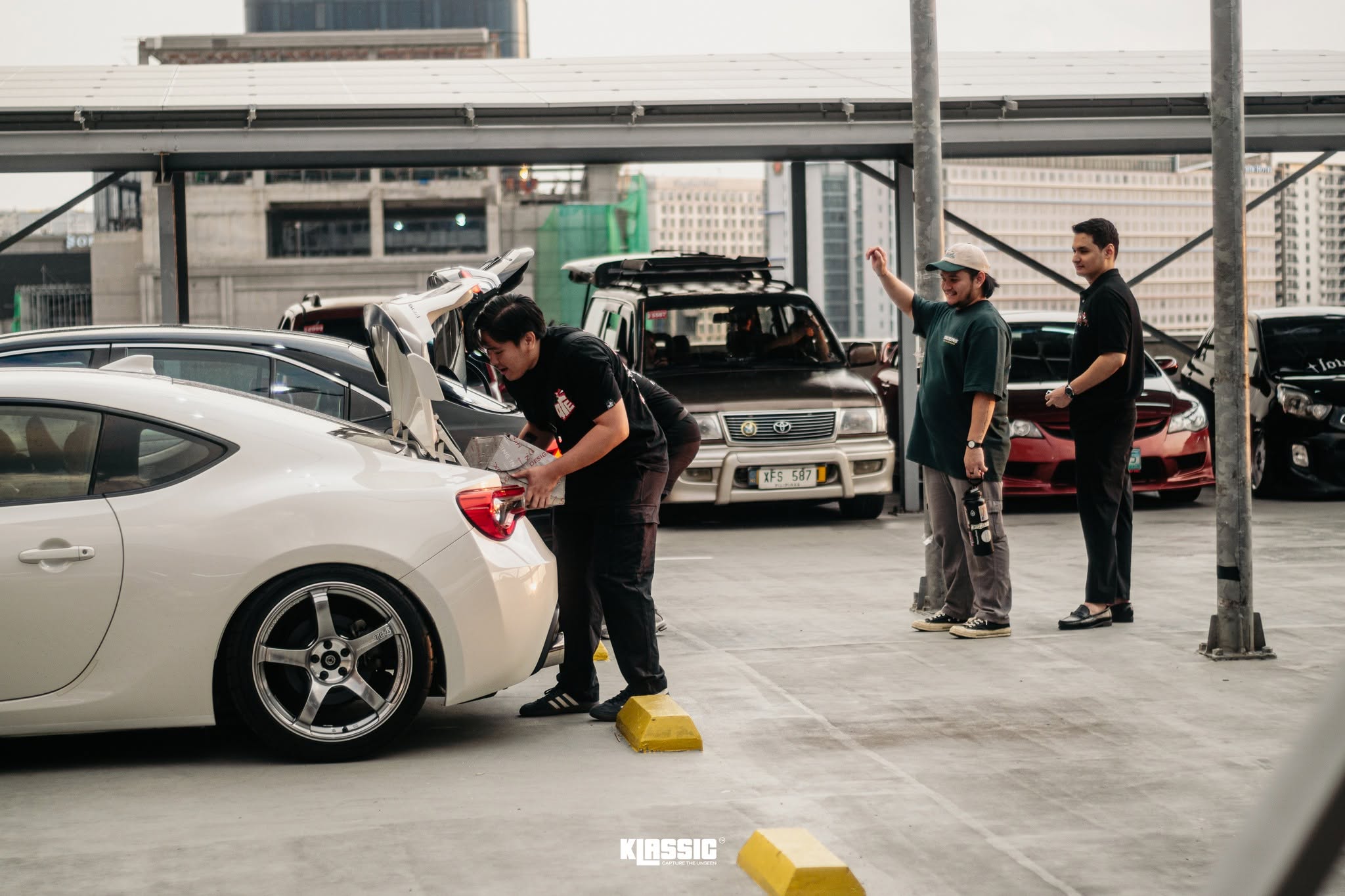 Club members loading up their cars together at a meet
