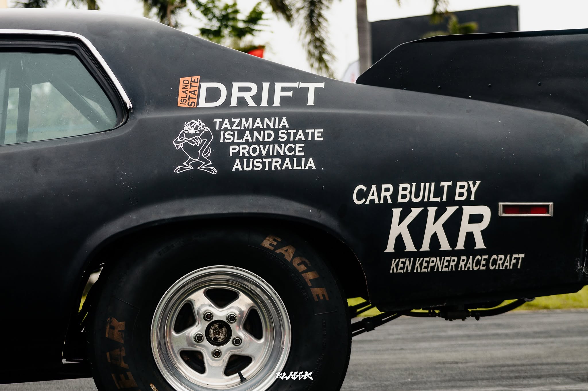 Close-up of a liveried drift car's door graphics at a car meet